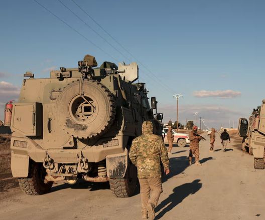 Military members gather near Raqqa prison, where the Syrian army is besieging SDF members after the army took control of the city of Raqqa, Syria, January 19, 2026